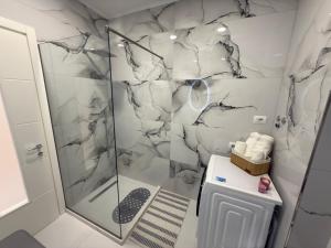 a bathroom with a shower with a glass door at City View Apartments in Durrës +45 photos