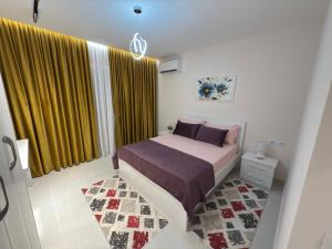 a bedroom with a bed and a yellow curtain at City View Apartments in Durrës