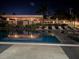 a swimming pool with chairs and a building at night at Hailey's Place in Bacolod