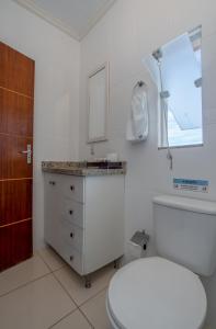 un bagno con un water, un lavandino e uno specchio di Pousada Villa D'Ouro a Penha Altre 102 foto