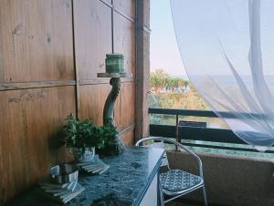 Una mesa con una planta y una lámpara en un balcón. en Le Rêve de Mer, en Ghisonaccia 36 fotos más