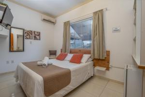 una camera da letto con un letto grande e una finestra di Pousada Villa D'Ouro a Penha