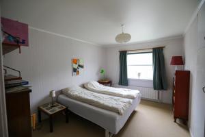 a bedroom with a bed and a window at VILLA ORANGE - Spacious piano home in Klaksvik in Klaksvík