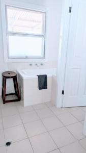 a white bathroom with a tub and a window at Hilltop Riverview Retreat in Clayton Bay +15 photos