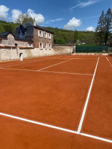 Una cancha de tenis con una pelota de tenis sobre ella en Maison des Fontainettes, en Les Andelys