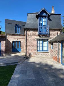 Una casa de ladrillo con un balcón encima. en Maison des Fontainettes, en Les Andelys