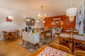 una cucina e una sala da pranzo con tavoli e sedie di Pousada Villa D'Ouro a Penha