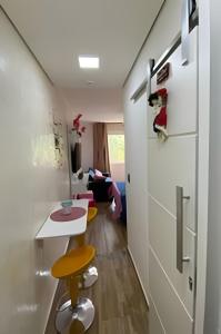 a room with a hallway with a table and a stool at BELO flat Cavalinho Branco-Aguas de Lindóia in Águas de Lindóia +35 photos