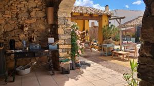 una casa in pietra con un muro in pietra e un patio di La Posada Rural el Ensueño a Alcublas