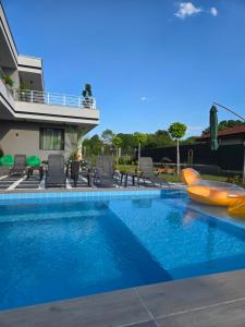 a swimming pool with a raft in a house at Къща за гости Вила Буч in Kvartal Mala Kutlovitsa