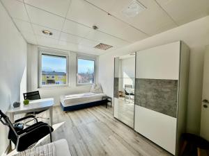 a room with a bed and a desk and windows at Kobra Apartment für Gruppen perfekt geeignet in Spielberg
