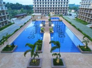 an overhead view of a large swimming pool with palm trees at Luxury poolview condo with pool access! in Suba +8 photos