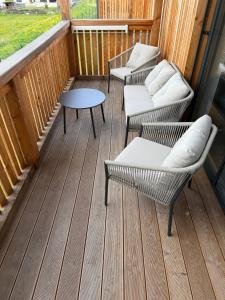 a porch with two chairs and a table and a table at Apartmán Hrabušice G3 - Slovenský Raj in Hrabušice