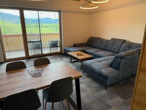 a living room with a couch and a table at Apartmán Hrabušice G3 - Slovenský Raj in Hrabušice