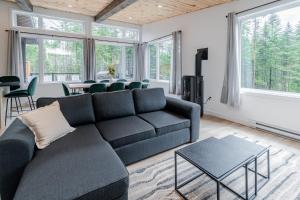 een woonkamer met een bank en een tafel bij Villa Le Frigg spa swimming pool in Valcartier Station