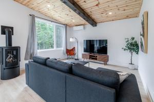 een woonkamer met een bank en een open haard bij Villa Le Frigg spa swimming pool in Valcartier Station