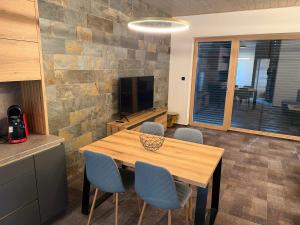 a dining room with a wooden table and blue chairs at Apartmán Hrabušice G3 - Slovenský Raj in Hrabušice