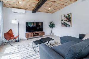 een woonkamer met een bank en een tv bij Villa Le Frigg spa swimming pool in Valcartier Station +53 foto's