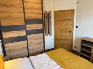 a bedroom with wooden sliding doors and a bed at Apartmán Hrabušice G3 - Slovenský Raj in Hrabušice