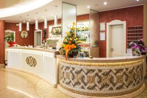 eine Lobby mit einer Theke mit Blumenarrangement darauf in der Unterkunft Hotel Miranda in Bellaria-Igea Marina