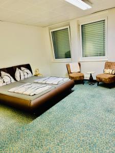 a bedroom with a large bed and two chairs at Kobra Room, 4 Personen in Spielberg