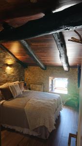 a bedroom with a large bed in a brick wall at Casa Antón O Cebreiro in O Cebrero