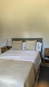 Santo António da CharnecaにあるCasa Silva Barreiroの白いシーツと枕が付いた大きなベッドのある寝室