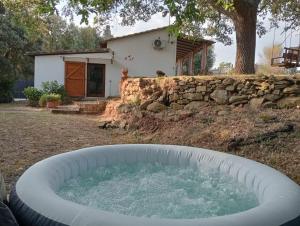 a large tub of water in front of a house at il poggetto di barbara casa bianca in Montorgiali +16 photos