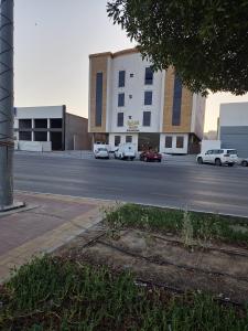 a parking lot with cars parked in front of a building at النخبة للشقق المخدومة in Hafr Al-Batin