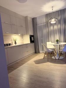 a kitchen and dining room with a table and chairs at Apartament przy rzece in Słupsk
