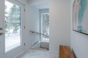 een gang met een raam en een bankje bij Chalet Odin - SPA, PISCINE, SAUNA partagés in Valcartier Station