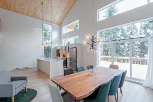 een keuken en eetkamer met een houten tafel en stoelen bij Chalet Odin - SPA, PISCINE, SAUNA partagés in Valcartier Station +53 foto's