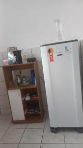 Un refrigerador blanco en una cocina al lado de un estante. en my sweet place 10, en São Luís