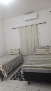 Dos camas en una habitación con paredes blancas. en my sweet place 10, en São Luís 3 fotos más