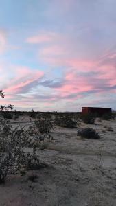 a building in the middle of a desert with a cloudy sky at Tee Pee at Maringa Serrano in Joshua Tree +21 photos