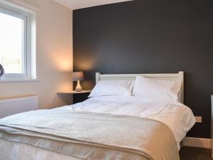 a bedroom with a white bed with a black wall at One Dorchester Drive - Uk32037 in Inglewhite