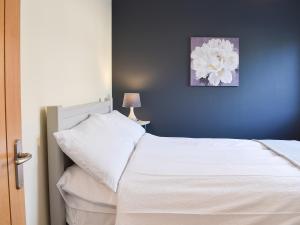 a bedroom with a white bed and a blue wall at One Dorchester Drive - Uk32037 in Inglewhite