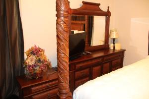 Oak ParkにあるBeautiful, Cozy Stay in Oak Park, Queen Bedroom, Work Setup & Backyard Grillのベッドルーム(鏡付きドレッサー、ベッド付)