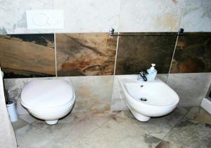 un baño con inodoro y lavabo en Isola dei sogni, en Alghero 2 fotos más