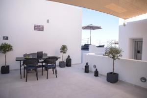 a dining room with a table and chairs and trees at AetherOia Suites in Oia