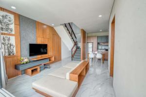 a living room with a couch and a television at Bhumi Villas 2BR Ricefield View in Canggu in Munggu