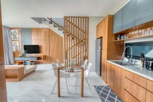 a kitchen with a glass table and white chairs at Bhumi Villas 2BR Ricefield View in Canggu in Munggu