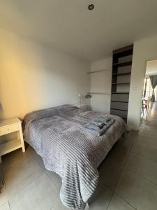 a bedroom with a bed with a blanket on it at NUX Tandil in Tandil