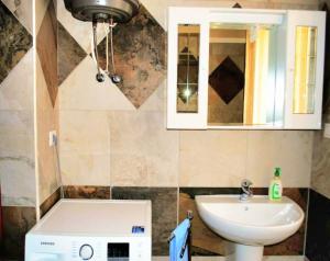 Un baño con lavabo, inodoro y espejo. en Isola dei sogni, en Alghero