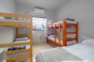 a dorm room with three bunk beds and a window at Pousada Selva Park in Penha