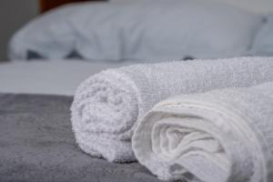 a roll of white towels on a bed at Pousada Selva Park in Penha