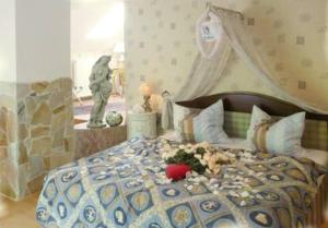 a bedroom with a bed with a flower arrangement on it at Das Romantische Landhaus in Kropp