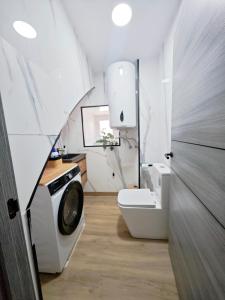 ein Badezimmer mit Waschmaschine und Toilette in der Unterkunft Casa boutique premium con diseño de autor y confort in Hinojosa del Duque