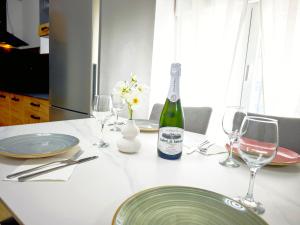 einen Tisch mit Tellern und Gläsern sowie eine Flasche Wein in der Unterkunft Casa boutique premium con diseño de autor y confort in Hinojosa del Duque