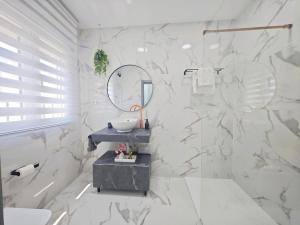 ein weißes Badezimmer mit Waschbecken und Spiegel in der Unterkunft Casa boutique premium con diseño de autor y confort in Hinojosa del Duque